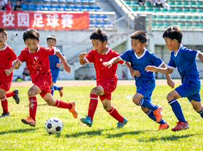 校园足球赛精彩瞬间 - 小学生们在绿茵场上带球奔跑、积极拼抢